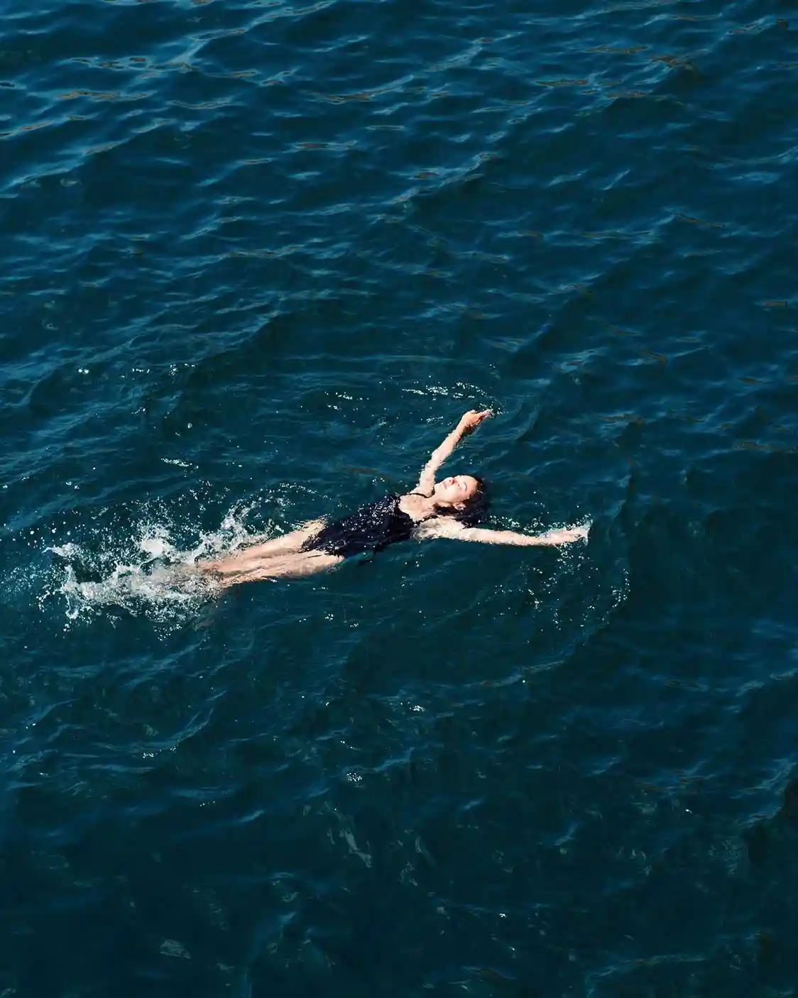 Eine Frau liegt entspannt im Wasser des Bodensees und genießt den Moment